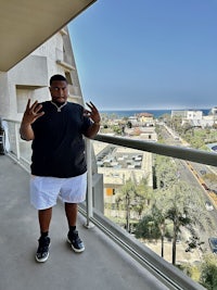 a man standing on a balcony with a view of the ocean